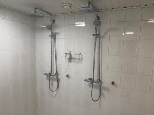 a shower in a bathroom with two shower heads at Nordic Nest B in Vantaa +1 photo