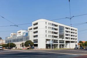 a white building on the corner of a street at Rebany Apartman 2 Free parking in Debrecen