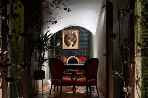 a dining room with red chairs and a table at Locanda Sibilla Luxury Suites in Tivoli
