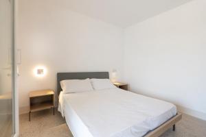 a bedroom with a white bed and two tables at Masseria l'Ulìa in Gallipoli +22 photos
