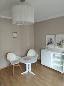 ein Esszimmer mit einem Tisch und zwei Stühlen in der Unterkunft KWATERA in Danzig