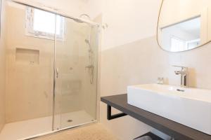 a bathroom with a shower and a sink and a mirror at Masseria l'Ulìa in Gallipoli