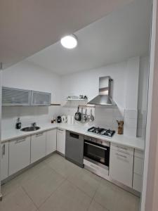 a white kitchen with a stove and a sink at Histadrout street 3 bedrooms central Ashdod in Ashdod