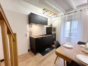 een keuken en eetkamer met een tafel en een eetkamer bij La Maison Bonheur - Authentique et Centrale in Cerizay