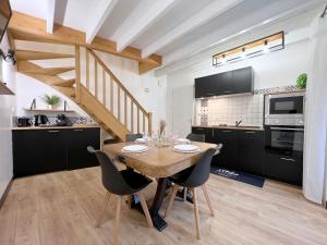 a kitchen and dining room with a wooden table and chairs at La Maison Bonheur - Authentique et Centrale in Cerizay