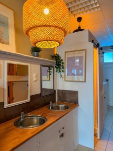 un bagno con due lavandini e un lampadario a braccio di Urban Capsule a Dresda