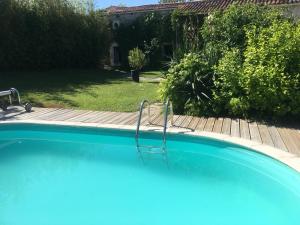 een groot blauw zwembad in een tuin bij Le phœnix in Linars