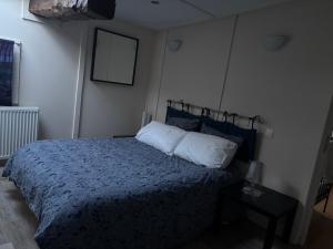 een slaapkamer met een bed met een blauw dekbed bij Le phœnix in Linars +1 foto