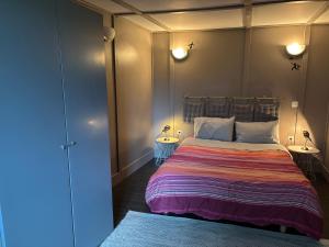 een slaapkamer met een groot bed en 2 tafels bij Le phœnix in Linars