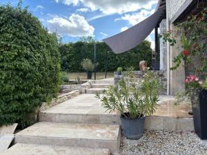 een tuin met trappen en planten en een paraplu bij Le phœnix in Linars