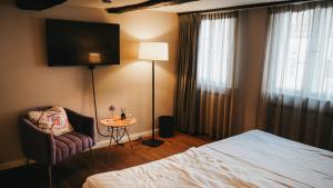 a hotel room with a bed and a table and a tv at Momento Heidkrug in Lüneburg