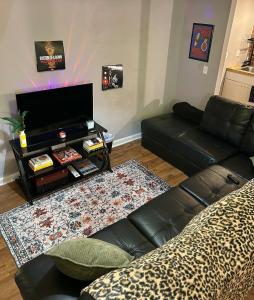 a living room with a black leather couch and a table at Boston Edison Cozy Gallery Studio in Detroit