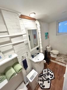 a white bathroom with a sink and a toilet at Boston Edison Cozy Gallery Studio in Detroit