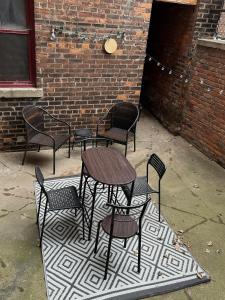 a group of chairs and tables on a rug at Boston Edison Cozy Gallery Studio in Detroit