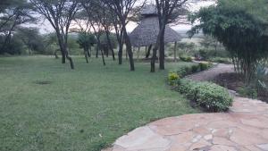 a park with a grassy area with a gazebo and trees at Mara Sunset Acacia Camp in Sekenani