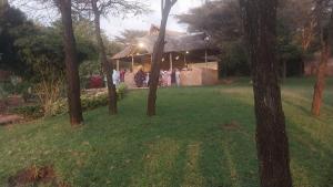 a group of people standing in front of a house at Mara Sunset Acacia Camp in Sekenani
