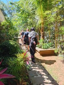 een groep mensen die over een pad in een tuin lopen bij Teirack Rosis Wish in Kandy