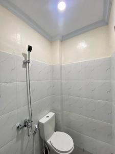 a white bathroom with a toilet in a room at Kalandra Living in Yogyakarta +21 photos