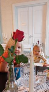 een klein meisje en een baby zitten aan een tafel bij Hostel Cafe Huvila in Oulu +4 foto's