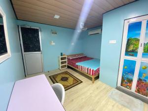 a blue room with a bed and a window at Umishah Cabin Jitra in Jitra