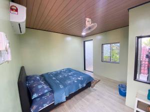 a bedroom with a bed in the corner of a room at Umishah Cabin Jitra in Jitra