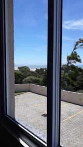a view of the ocean from a window at Apartamento em Imbituba in Imbituba