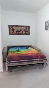 a bed with a colorful blanket on it in a room at Domu S'Aratzia - Vicino al mare - con parcheggio privato in Quartu Sant'Elena
