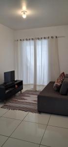 a living room with a couch and a piano at Apartamento em Imbituba in Imbituba