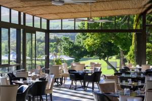 a restaurant with tables and chairs and a large window at Webersburg in Stellenbosch