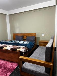 een slaapkamer met 2 bedden en een bank erin bij Norkyi Homestay in Tawang