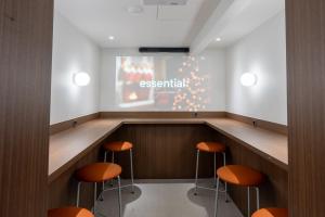 a waiting room with orange stools in front of a screen at Vinetree Boutique Hotel in Seoul
