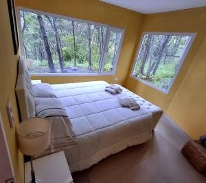 una camera con un grande letto e due finestre di Familia Piatti B&B - Suites a Ushuaia