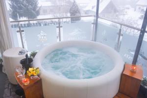 a bath tub with snow in a room with a window at Hotel Tommy Wellness & Spa in Náchod