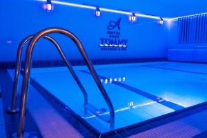 een zwembad met blauwe verlichting en leuningen erin bij Hotel Tommy Wellness & Spa in Náchod +72 foto's