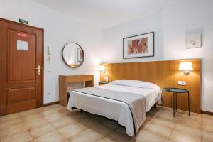 una camera da letto con un letto grande e uno specchio di MURÇAS 74 - STUDIO APARTMENTS a Funchal