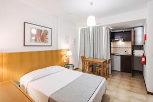 una camera da letto con un letto, un tavolo e una cucina di MURÇAS 74 - STUDIO APARTMENTS a Funchal