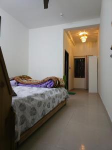 a bedroom with a bed and a room with a refrigerator at JMC Homestay in Kukri Ser +5 photos