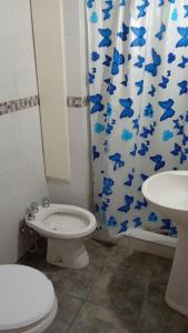 a bathroom with a toilet and a shower curtain with blue fish at Yanel in Mar del Tuyú