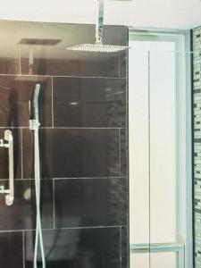 ein Bad mit einer Dusche und schwarzen Fliesen in der Unterkunft Spectacular views Atlantic Ocean in Basseterre