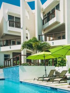 ein Swimmingpool mit Stühlen und Sonnenschirmen vor einem Gebäude in der Unterkunft Spectacular views Atlantic Ocean in Basseterre