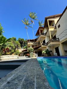 un resort con piscina di fronte a un edificio di Pousada Vila Verde a Olivença