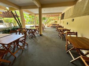 a row of wooden tables and chairs in a restaurant at Pousada Vila Verde in Olivença