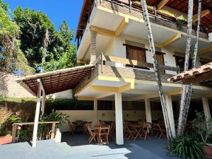 una casa con balcone arredato con tavoli e sedie di Pousada Vila Verde a Olivença