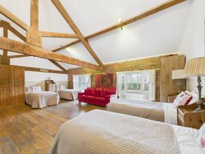 una camera con due letti e un divano rosso di The Old Granary Country-retreat a Burton Agnes