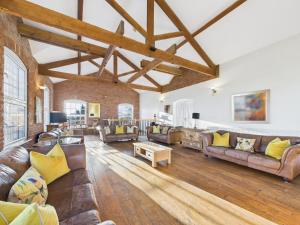 un soggiorno con mobili in pelle e un muro di mattoni di The Old Granary Country-retreat a Burton Agnes