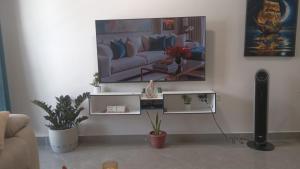 a living room with a couch and a tv on the wall at 4K-Suite in Kingston