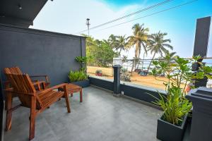 a wooden chair on a balcony with a view of a beach at Mawakada Bay Residences in Hikkaduwa
