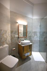 a bathroom with a sink and a toilet and a mirror at Mawakada Bay Residences in Hikkaduwa +30 photos