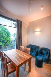 a living room with a wooden table and chairs at Mawakada Bay Residences in Hikkaduwa
