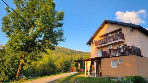 a house on the side of a road next to a tree at Apartments Žugec in Seliste Dreznicko